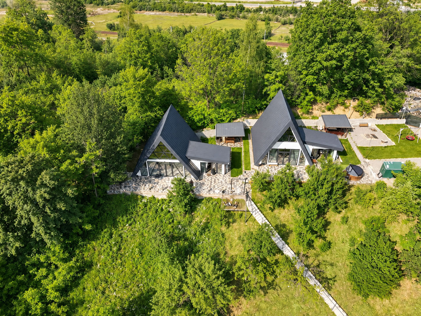 Cele două cabane A-frame înconjurate de pădure, ziua